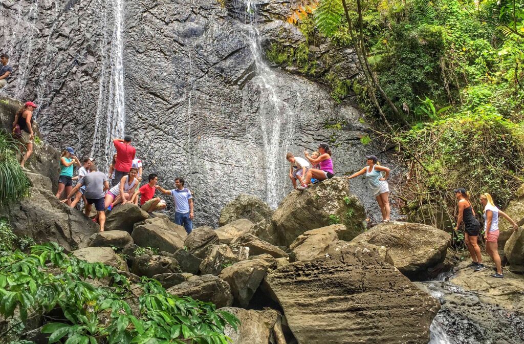 ©EDSA | El Portal Tropical Rainforest Center | People on Rocks In Front of Waterfall
